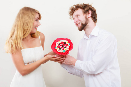 幸福的夫妇用糖果束鲜花。爱