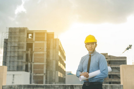 微笑年轻建筑师或工程安全帽与生成器