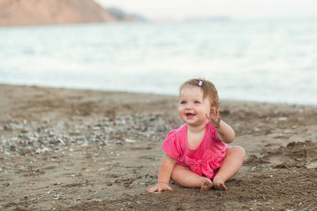可爱的小女孩坐在海滩上
