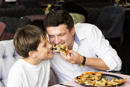 父亲儿子吃意大利的比萨饼图片
