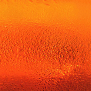 啤酒。打玻璃的啤酒泡沫的美丽细节。抽象的彩色背景