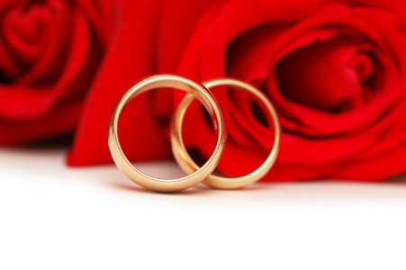 两个结婚戒指和红色的玫瑰