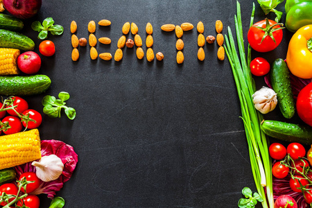 照片一张桌子顶充满新鲜蔬菜或健康食品背景。健康食品的概念与烹饪的新鲜蔬菜。标题健康由螺母