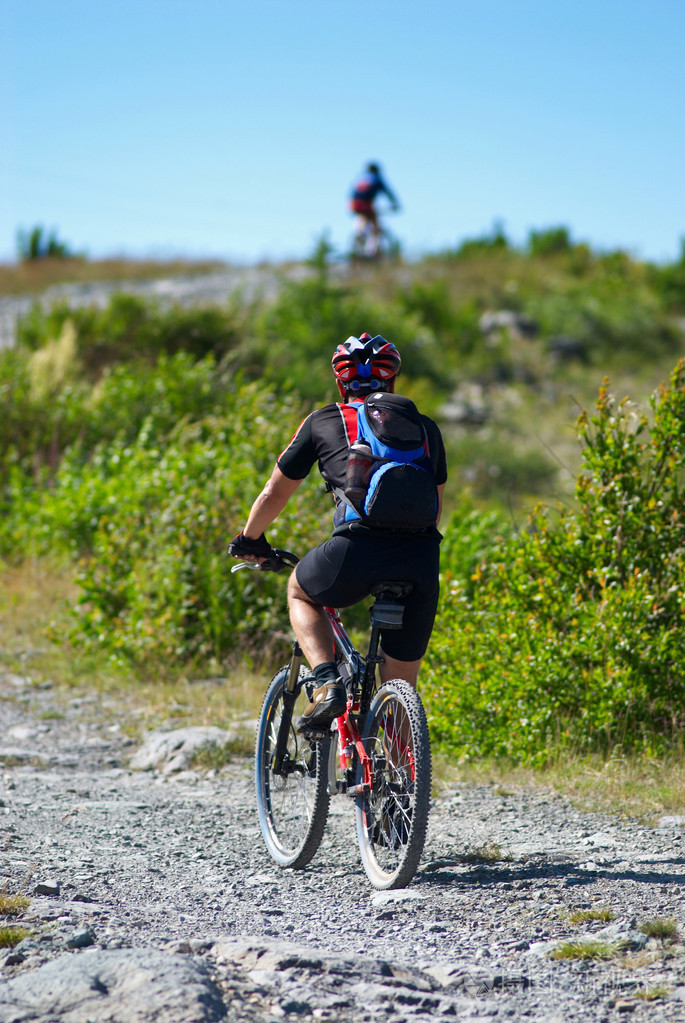 两个骑自行车的人上山在农村公路上