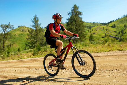 山区农村道路上骑自行车的人图片