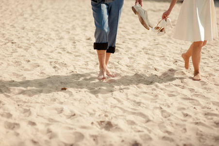 新郎和新娘的脚在沙滩上