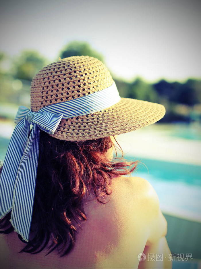 漂亮的女人戴着草帽她在旅游重新放松