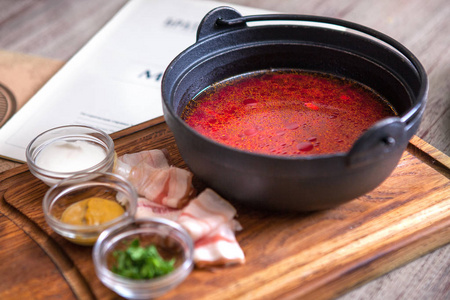 宝狮传统乌克兰和俄罗斯红甜菜在木制背景上的陶瓷碗汤