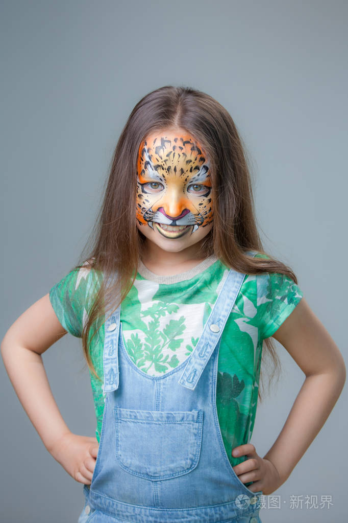 美丽的女孩与老虎画在他的脸上灰色背景