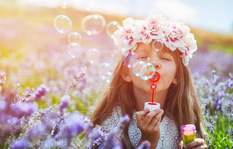 儿童女孩吹肥皂泡泡,开心的薰衣草田照片