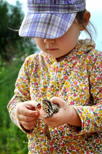 一个可爱的年轻孩子女孩手里拿着一只青蛙蟾蜍和笑