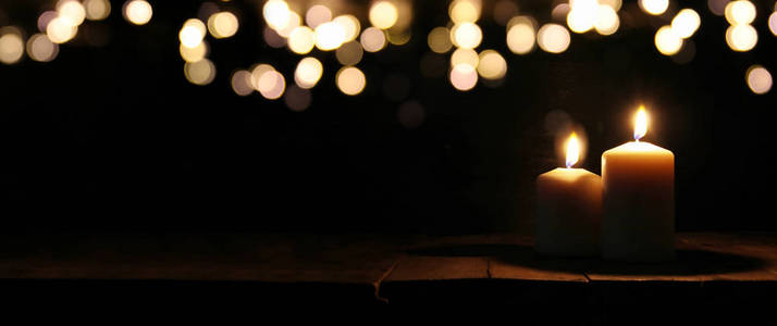 燃烧的蜡烛，在黑色的背景，散景亮灯