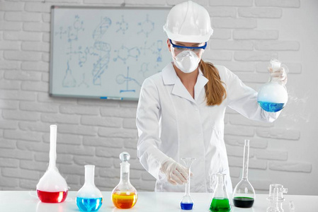 这位科学家进行了研究与化学液体在白色的实验室照片