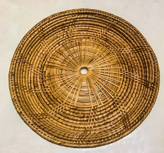 空竹藤编织盘餐垫白色大理石桌子上作为背景
