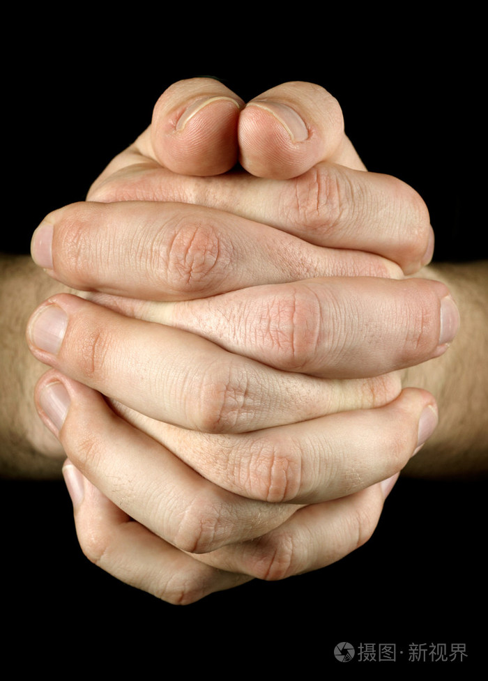 在黑色背景下祈祷双手