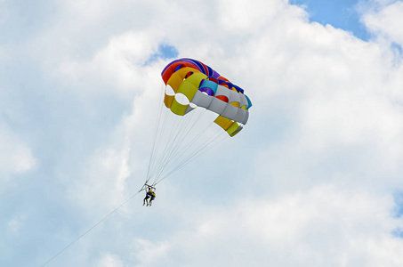 彩色 parasail 翼在蓝云的天空，水上滑翔伞