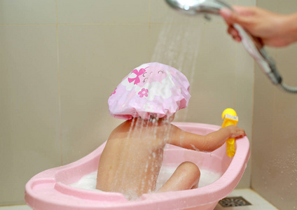 快乐小孩戴帽的泡沫浴照片