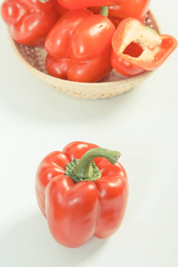 老式的照片，在白色的背景下，健康营养的柳条篮子红色成熟青椒