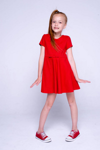 漂亮的小红发女孩穿着红色的裙子和运动鞋构成 l