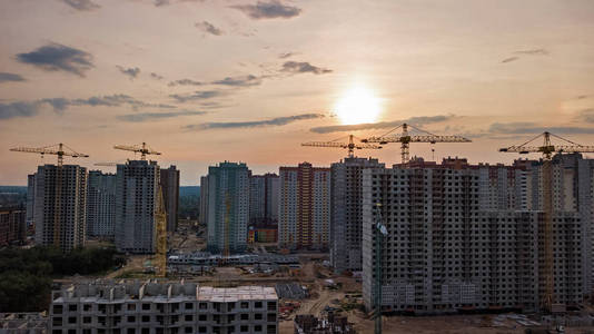 施工现场的住宅区建筑用起重机在日落时从乌克兰基辅市的城市天际线的鸟瞰图