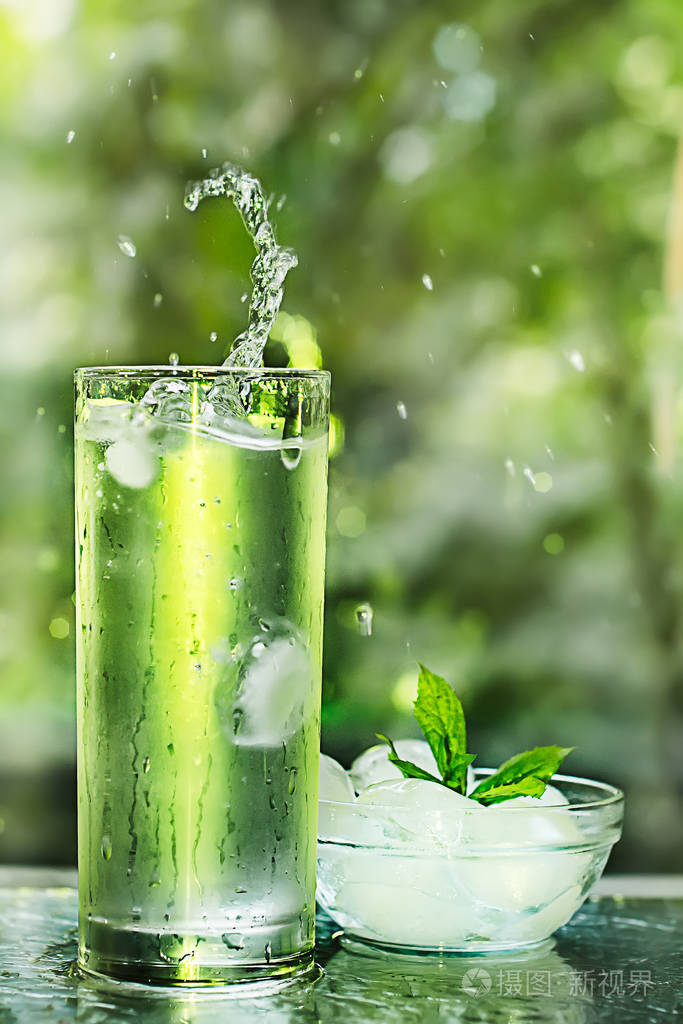 与冰和薄荷清凉新鲜的水源.在玻璃飞溅.健康生活概念