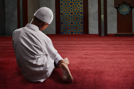 礼拜亚洲在清真寺做礼拜的穆斯林孩子照片