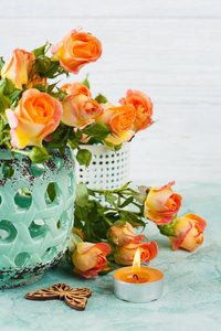 鲜橙色玫瑰鲜花薄荷花瓶，蜡烛