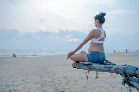 自然怀孕女人练瑜伽在海边