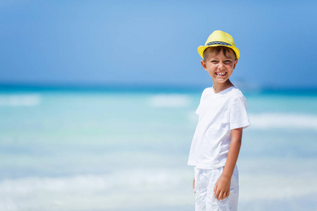 在热带海洋沙滩上玩耍的男孩。孩子在家庭海度假期间