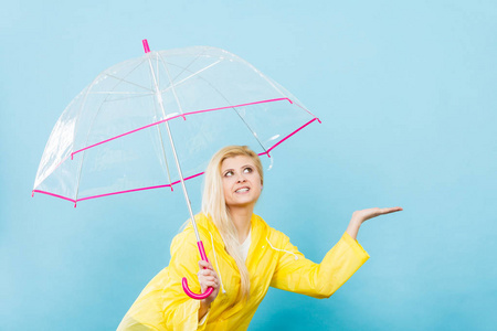 女人穿着雨衣打着伞检查天气