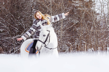 好女孩和白马在森林里一个冬天