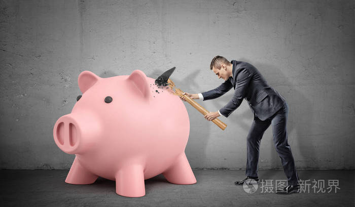 失意的商人在固体储钱罐大打破他大锤子照片-正版商用图片013dtf-摄图