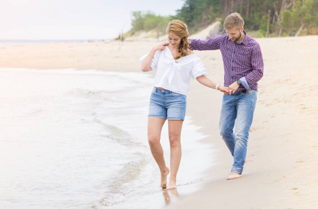 年轻夫妇沿着海走上海滩举行的爱情