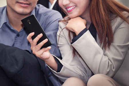 亚洲业务的女人和男人微笑和手机一起使用