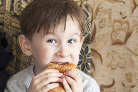 饥饿的男孩用食欲面包吃图片