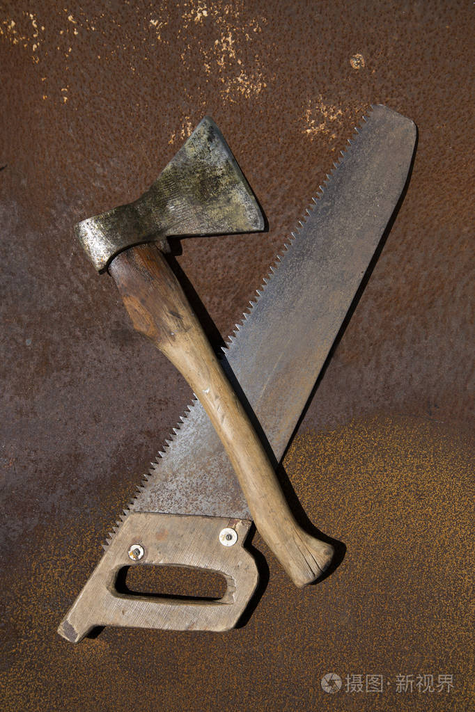 老ax和生锈的金属板上的老木锯