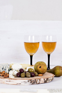 白葡萄酒和小吃。葡萄酒 葡萄 奶酪 坚果 橄榄。浪漫之夜静物