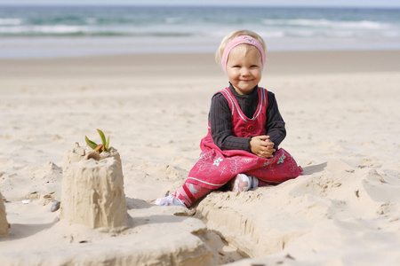 微笑的小女孩在海滩上玩耍