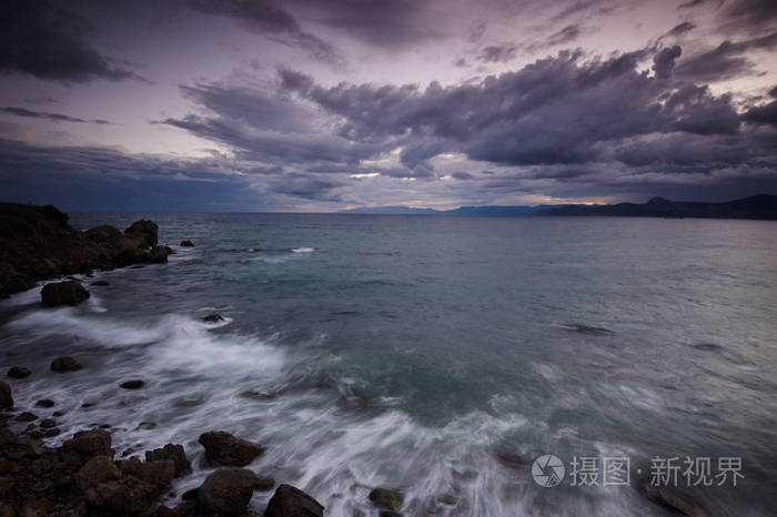 多姿多彩的夏天海景。在日落时的岩石海岸