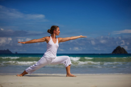 练瑜伽在海滨的热带海洋的白种女人