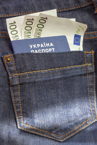 在口袋里的钱与牛仔裤的乌克兰护照