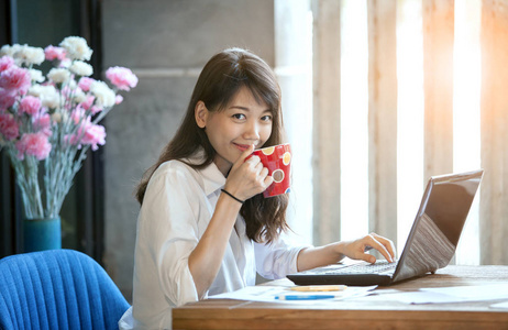 幸福笑脸年轻亚裔女子喝热咖啡