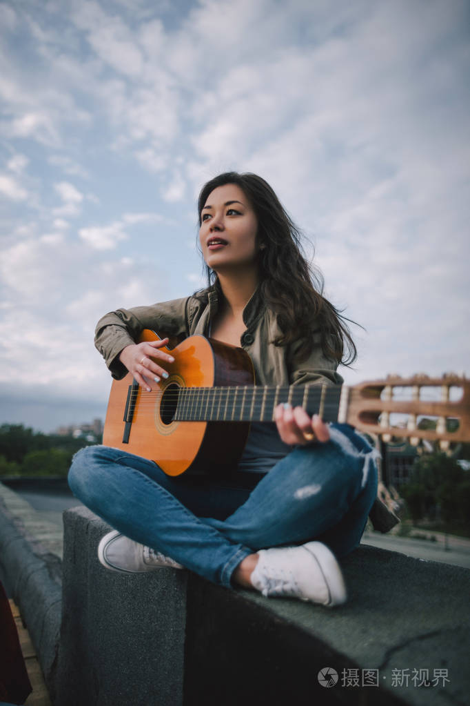 免费的音乐女吉他手弹在大街上