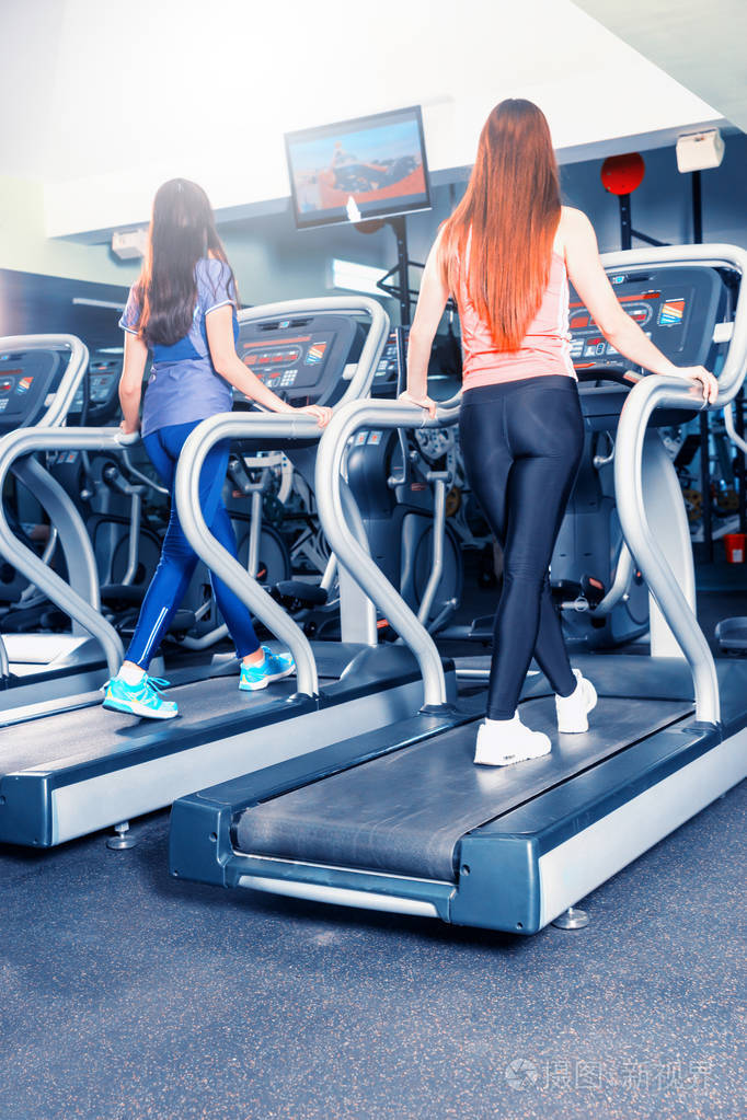 年轻健康的女性在跑步机上锻炼后视图