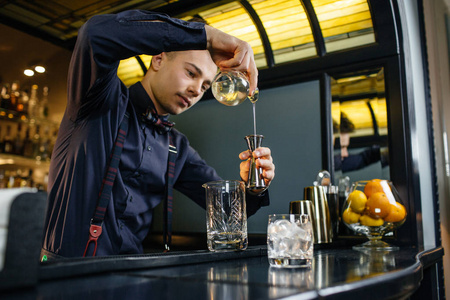 酒保制作鸡尾酒在酒吧照片