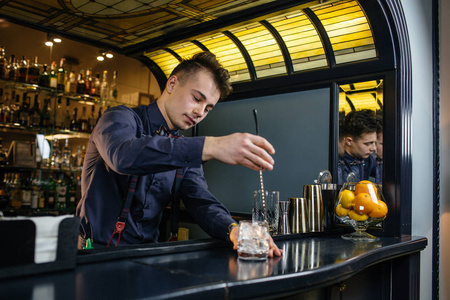 酒保制作鸡尾酒在酒吧照片