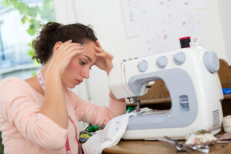 年轻的女裁缝妇人，有缝纫机的困难