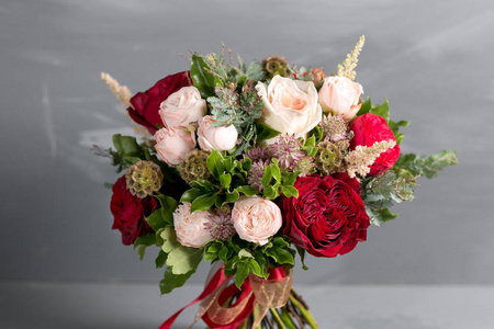 新娘美丽花束，用不同的花卉，在灰色的背景上做成。缤纷的色彩组合花。特写