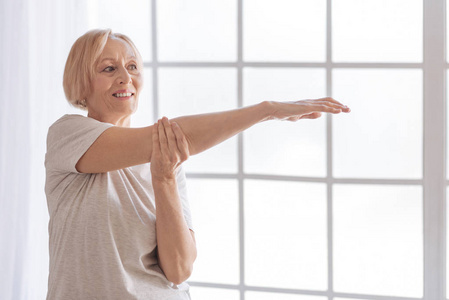 积极高兴退休的妇女伸展她的手臂