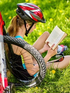 自行车骑自行车戴头盔的女孩读本书其余附近自行车